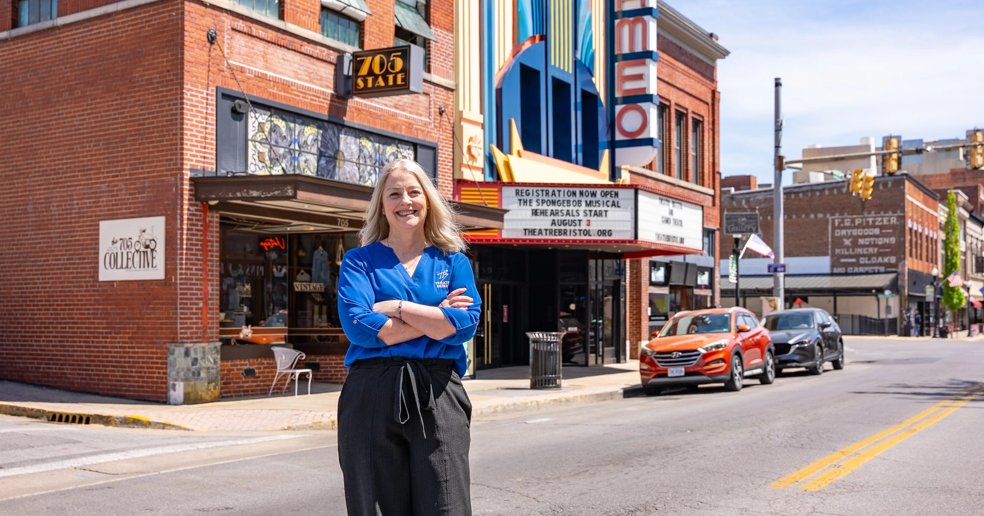 A smiling woman stands in the street in front of Theater Bristol in Bristol VA